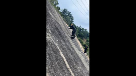 Man rides electric unicycle up and down slanted wall in Sichuan, China