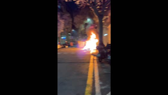Man tries to extinguish burning rubbish bin amid unrest in Barcelona, Spain