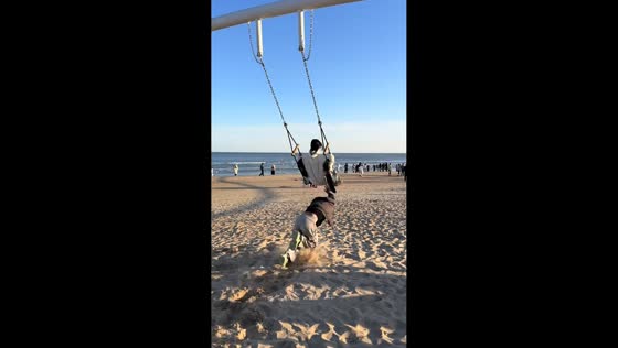 Swing push ends in a sandy fall on a beach in Beijing, China