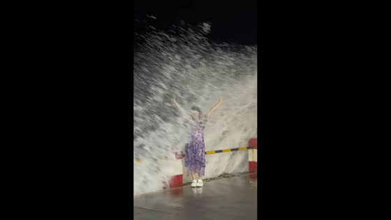 Woman gets soaked by sudden wave while posing by the sea in Guangdong, China