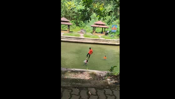 Person jumps into water, lands on another swimmer