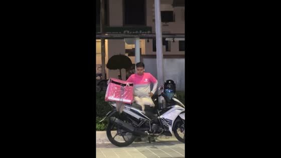 Delivery man persuades cat off his motorcycle in Kuala Lumpur, Malaysia