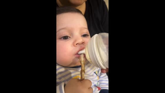 Baby enjoys meat while drinking milk in Baku, Azerbaijan