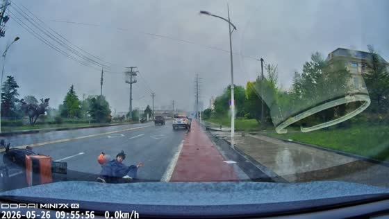 Delivery rider slides across wet road during rainy-day crash in Shandong, China