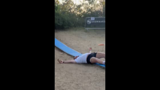 Man slips and spills drink during backyard slide attempt in Pfungstadt, Germany