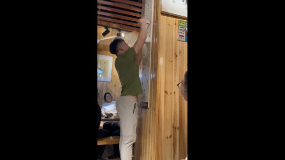 Man climbs wall using wooden sticks in Beijing, China
