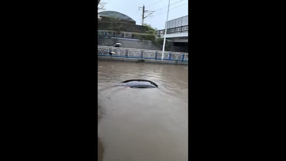 Severe flooding nearly submerges car beneath overpass in Qinhuangdao, China