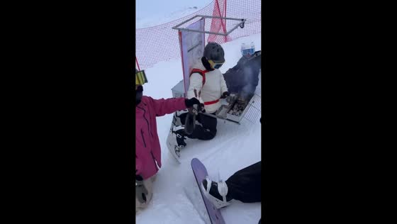 Man gives out barbecue on a snowy mountain in Xinjiang, China