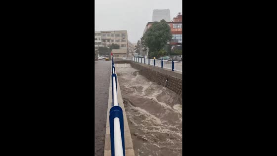 Overflowing drainage channel floods roadway after intense rainstorm in Jinan, China
