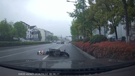 Helping a fallen motorcyclist on slippery road
