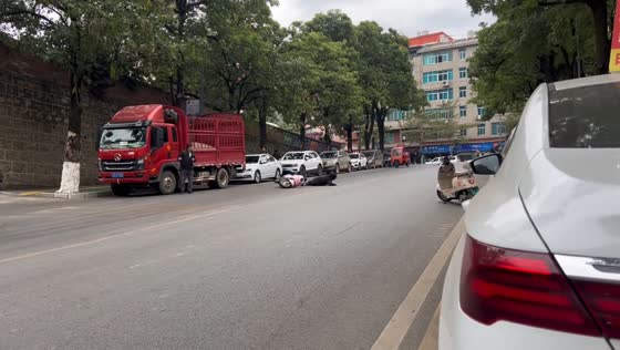 Two riders fall on slippery road in Yunnan, China