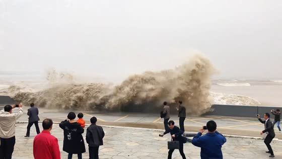 High tide waves splashing over Qiantang River embankment in Zhejiang, China