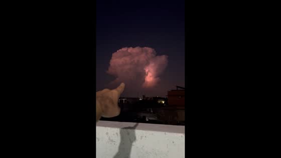 Towering lightning storm cloud illuminates the night sky in Fateh Jhang, Pakistan