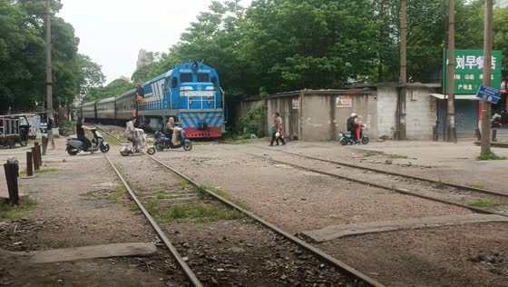 Train briefly stops to let people cross railway in Jiangxi, China