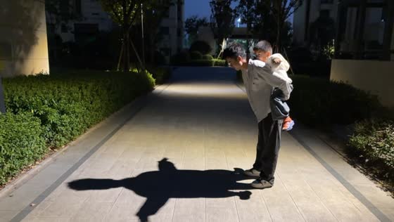 Boy creates a hilarious turtle-shaped shadow while riding on a man’s back in Hunan, China