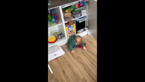 Toddler unexpectedly hit by bouncing cabinet door during playful tantrum