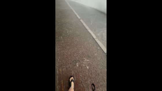 Pedestrian walks through flooded street during heavy rain in Heilongjiang, China