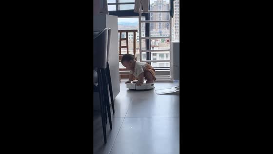 Toddler rides robotic vacuum cleaner in playful moment in Hunan, China