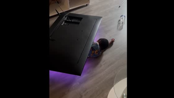 Child lays under fallen TV while watching cartoon in Villeneuve-le-Roi, France
