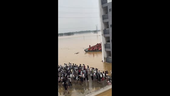 Large rescue boat carries people through severely flooded residential area in Guangdong, China