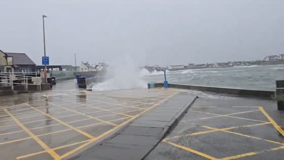 Powerful Atlantic waves crash over breakwater in Trearddur Bay, UK