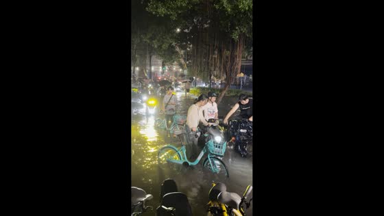 Vehicles continue driving through flooded street in Guangdong, China