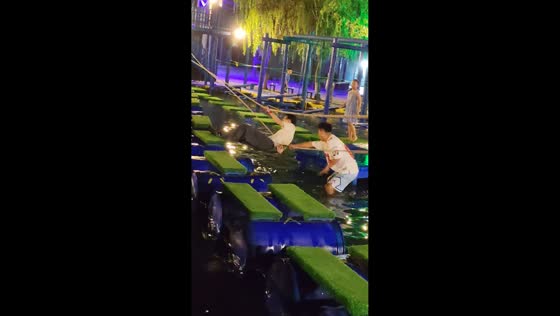 Man nearly falls while crossing floating obstacle course in Liaoning, China