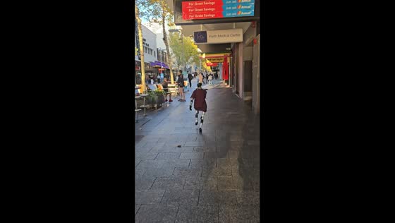 Humanoid robot strolls through city centre to buy shoes for charity run in Perth, Australia