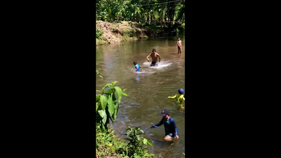 Boy cries as capybara climbs on him in the water in Puyo, Ecuador