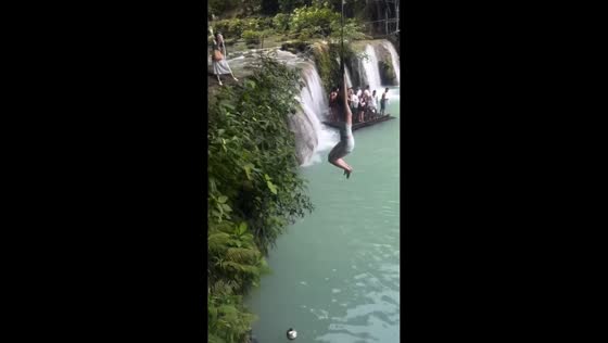Woman swings over waterfall in Guizhou, China