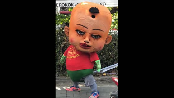 The creepy baby mascot was found dancing in the streets of Indonesia.