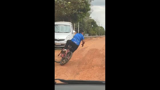 Boy falls off bicycle while climbing steep hill in Colonel Oviedo, Paraguay