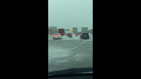 Electric sports car drives through flooded roadway in Shanghai, China