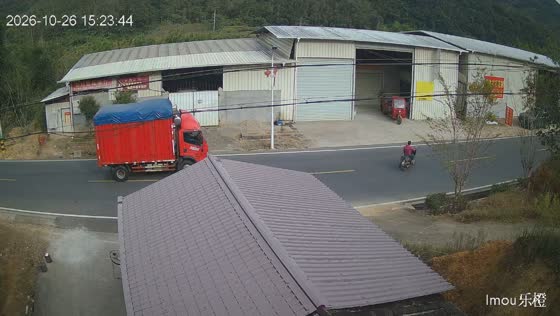 Truck narrowly avoids motorcycle rider and workers near a warehouse in Fujian, China