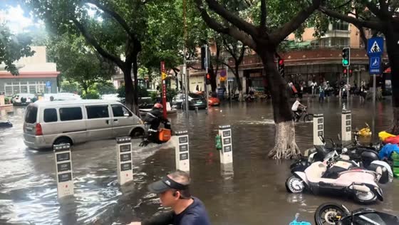 Delivery rider crosses flooded road in unusual position in Guangdong, China