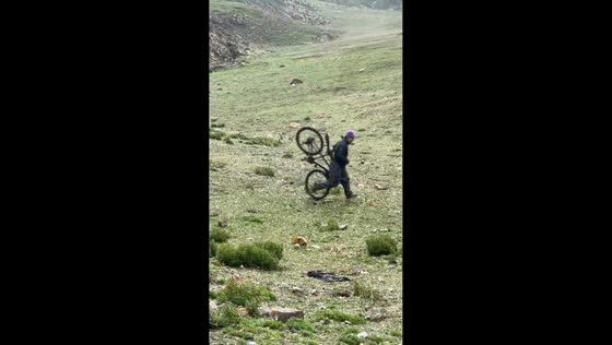 Cyclist loses balance on rocky downhill slope in Tibet, China