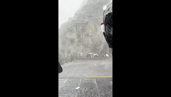 Tourists caught in sudden summer rainstorm at Longmen Grottoes in Henan, China