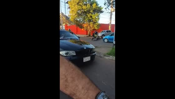 Motorbike narrowly avoids collision at intersection before riders fall in Asunción, Paraguay