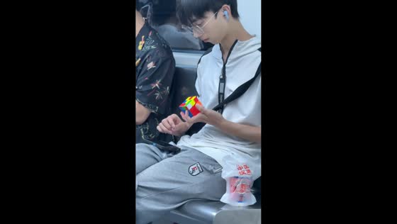 Man solves Rubik's Cube while looking at phone in Zhejiang, China
