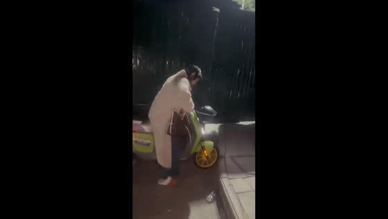 Woman loses balance while riding electric motorcycle up steps in Yunnan, China