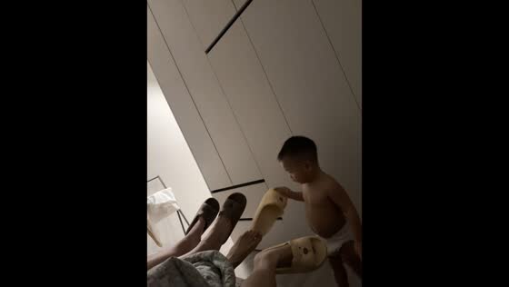 Toddler repeatedly puts slipper back on parent's foot in Anhui, China
