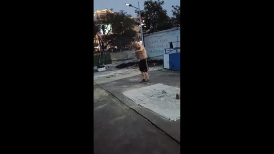 Man performs precise outdoor strength routine with cement dumbbell in Jiangsu, China