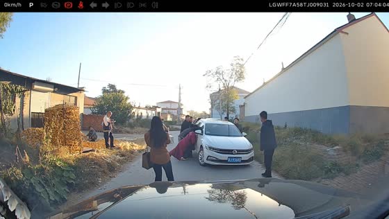 Bystanders lift slanted white car to clear road in Hebei, China