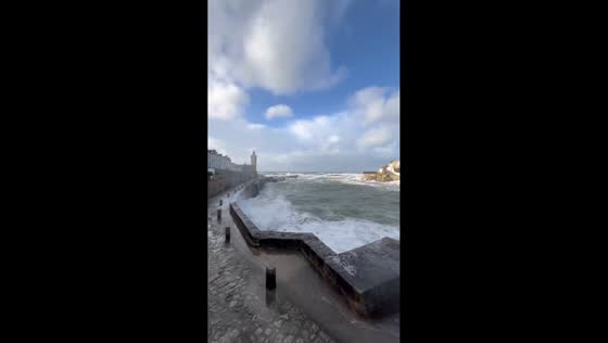 Powerful waves slam into Porthleven harbour during Storm Chandra in Porthleven, Cornwall, UK
