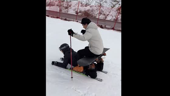Two people create sleigh and slide on snow in Shandong