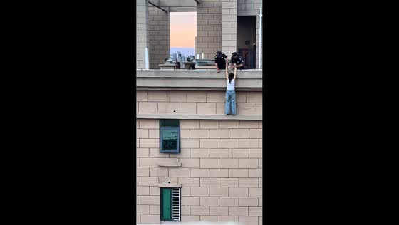 Police rescue woman attempting to jump from building in Henan, China