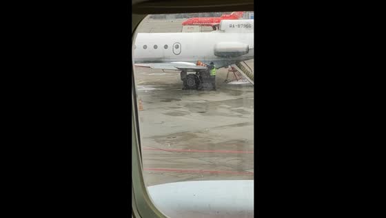 Airport employee uses traffic cone to clear ice from plane in Vnukovo, Russia