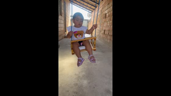 Toddler dozing on swing in Betim, Brazil