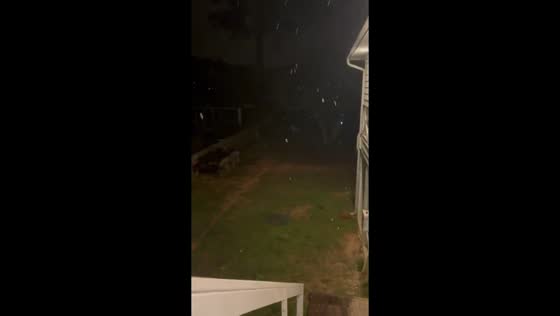 Light snowfall drifts through backyard during rare winter storm in Pensacola, Florida, USA