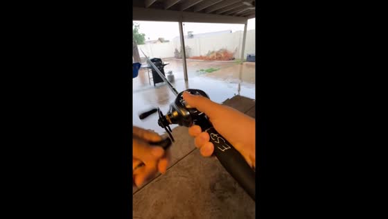 Man humorously goes fishing in his flooded backyard in Chandler, Arizona, USA
